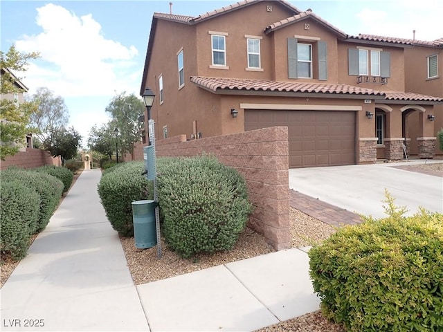 4361 Duck Harbor Ave, North Las Vegas, NV 89031 - mediterranean / spanish house featuring driveway, a tile roof, a garage, stone siding, and stucco siding