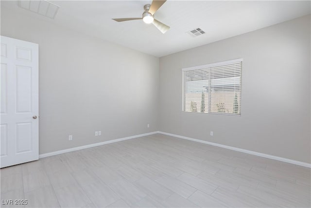 unfurnished room featuring baseboards, a ceiling fan, and visible vents