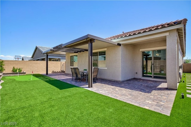 back of property featuring fence, stucco siding, and a patio area