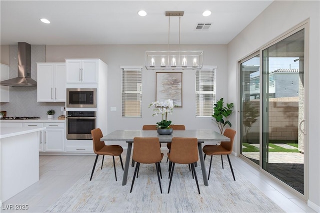 dining room with an inviting chandelier, recessed lighting, and visible vents