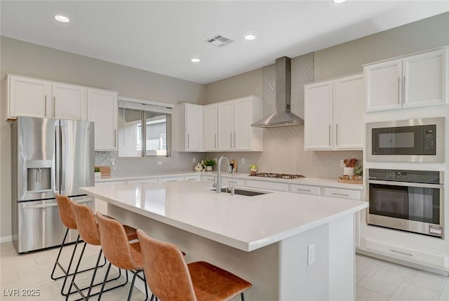 10251 Tiger Milkweed St, Las Vegas, NV 89141 - kitchen featuring appliances with stainless steel finishes, wall chimney exhaust hood, tasteful backsplash, light countertops, and recessed lighting