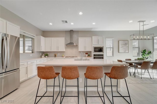 10251 Tiger Milkweed St, Las Vegas, NV 89141 - kitchen with freestanding refrigerator, wall chimney range hood, oven, built in microwave, and healthy amount of natural light