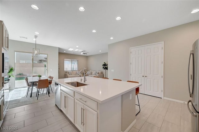 10251 Tiger Milkweed St, Las Vegas, NV 89141 - kitchen with appliances with stainless steel finishes, an island with sink, light countertops, white cabinetry, and hanging light fixtures