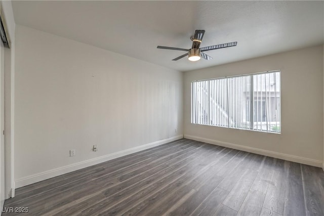 unfurnished room featuring baseboards, a ceiling fan, and dark wood-style flooring