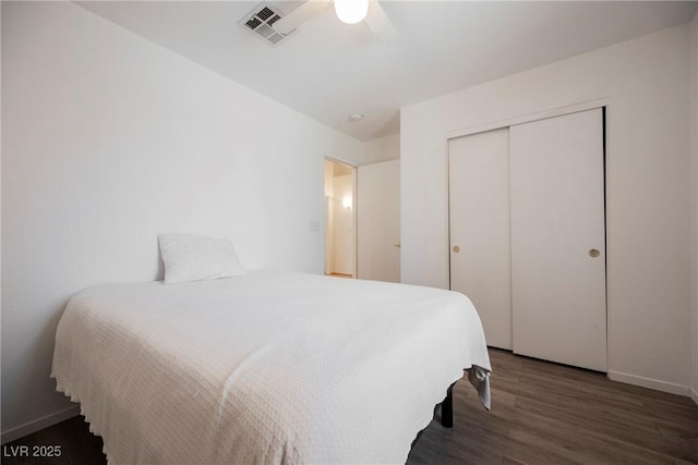 bedroom featuring ceiling fan, baseboards, wood finished floors, visible vents, and a closet