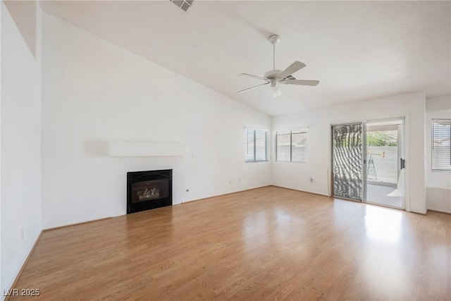 unfurnished living room featuring a glass covered fireplace, a ceiling fan, light wood-type flooring, and lofted ceiling