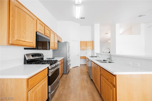 kitchen with visible vents, light wood-style floors, light countertops, a sink, and appliances with stainless steel finishes