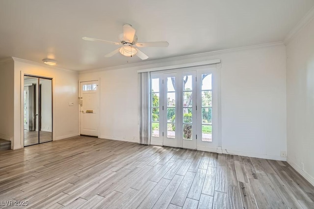 unfurnished living room featuring light wood-style flooring, ornamental molding, a ceiling fan, and baseboards