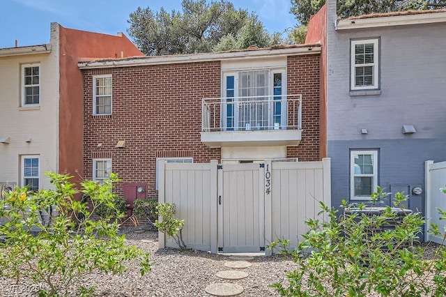 1034 Tam O Shanter, Las Vegas, NV 89109 - view of property exterior with brick siding, a gate, fence, and a balcony