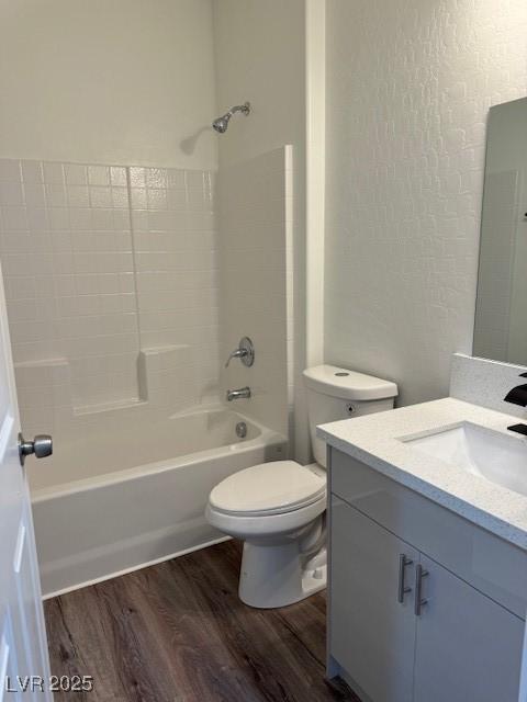 full bathroom with vanity, bathing tub / shower combination, toilet, and wood finished floors