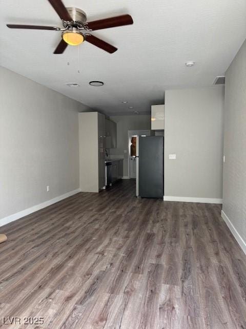 unfurnished living room with visible vents, a ceiling fan, baseboards, and dark wood-style floors