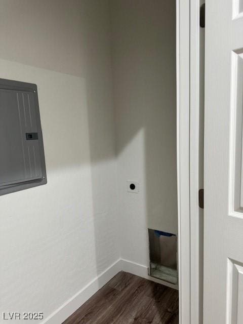 washroom featuring dark wood-style flooring, laundry area, baseboards, electric dryer hookup, and electric panel