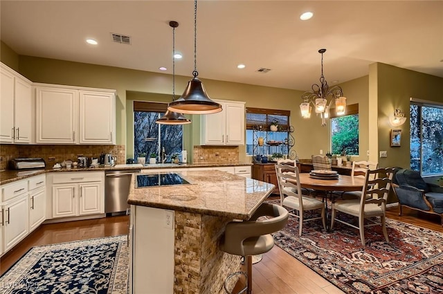 kitchen featuring backsplash, stainless steel dishwasher, light stone countertops, dark wood finished floors, and white cabinetry