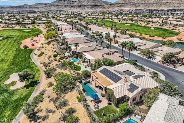 drone / aerial view with view of golf course, a mountain view, and a residential view