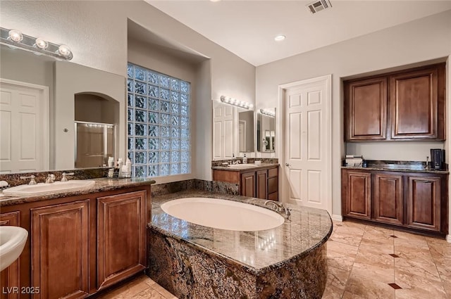 bathroom featuring a sink, a stall shower, a garden tub, and visible vents