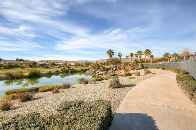view of home's community featuring a water view and fence
