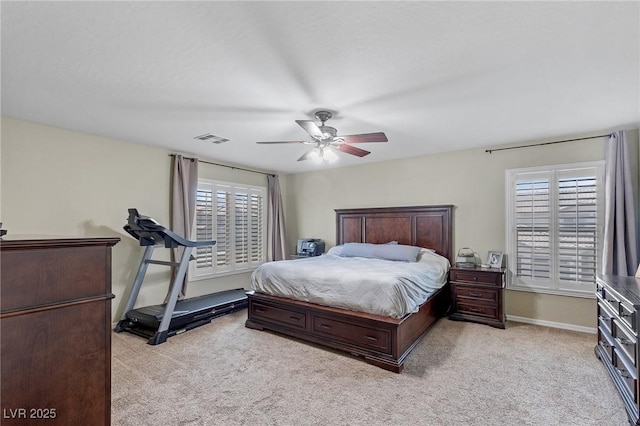 bedroom featuring visible vents, multiple windows, and light carpet
