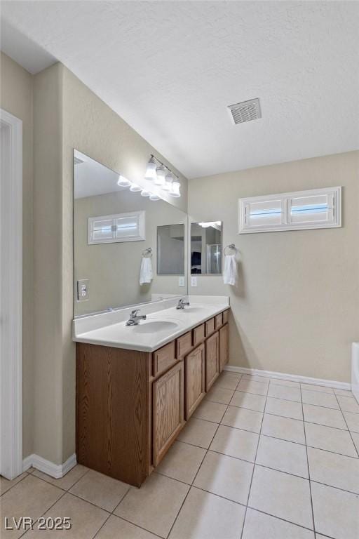bathroom with tile patterned flooring, a sink, double vanity, and visible vents