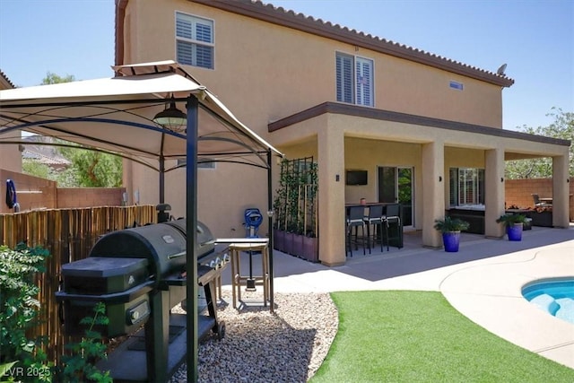 back of property with fence, a fenced in pool, stucco siding, and a patio area