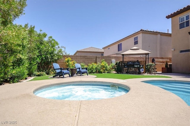 view of swimming pool featuring fence, a patio, a gazebo, and an in ground hot tub