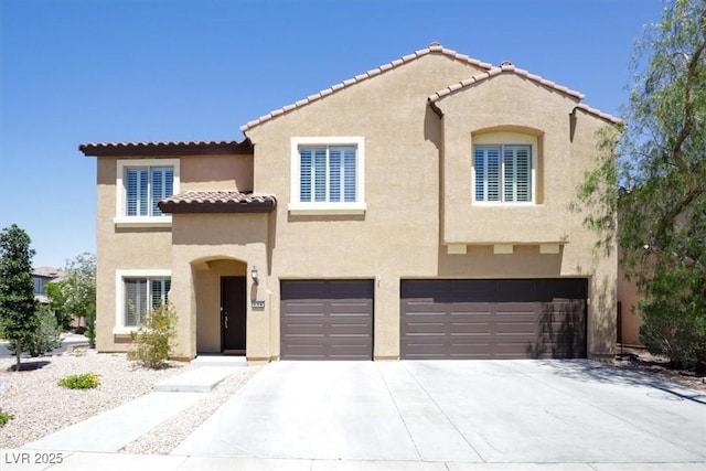 mediterranean / spanish-style house with an attached garage, stucco siding, a tiled roof, and concrete driveway