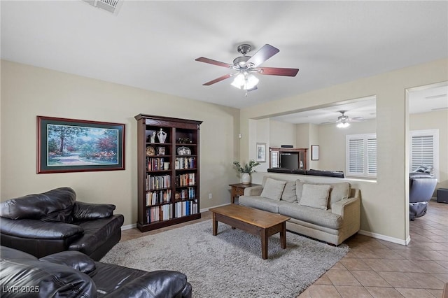 living area featuring a ceiling fan, baseboards, visible vents, and light tile patterned flooring
