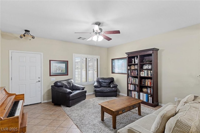 living room featuring light tile patterned flooring, ceiling fan, visible vents, and baseboards