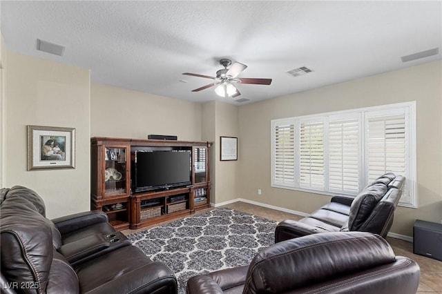 tiled living area featuring ceiling fan, visible vents, and baseboards