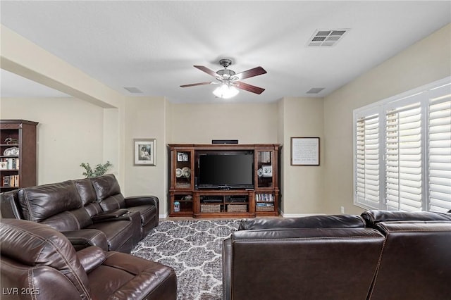 living room with visible vents, a ceiling fan, and baseboards