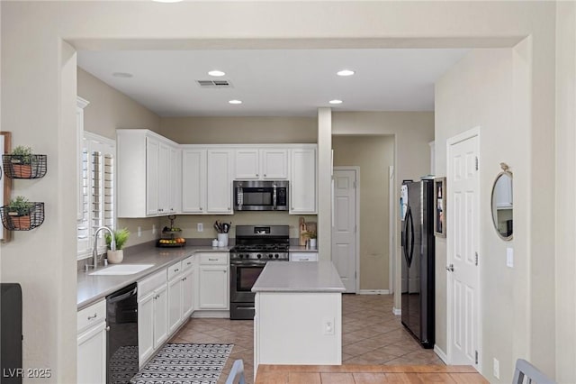 kitchen with a sink, light countertops, stainless steel appliances, white cabinetry, and visible vents