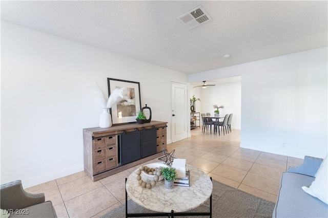 3151 Soaring Gulls Dr Unit 1168, Las Vegas, NV 89128 - living room featuring visible vents, light tile patterned flooring, baseboards, ceiling fan, and a textured ceiling