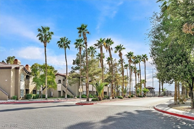 view of road featuring a residential view, sidewalks, traffic signs, and curbs
