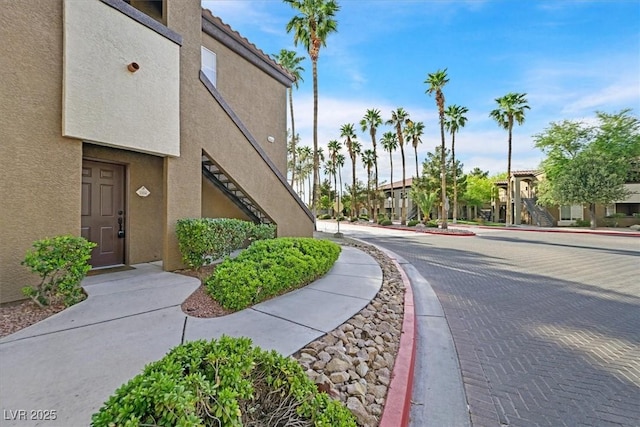 view of road featuring stairs, curbs, sidewalks, and a residential view