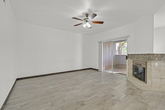 unfurnished living room with ceiling fan, baseboards, light wood-style floors, and a fireplace