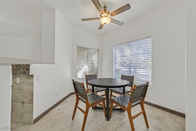 dining space with baseboards and a ceiling fan