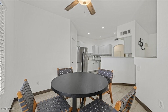 dining space featuring arched walkways, ceiling fan, visible vents, and baseboards