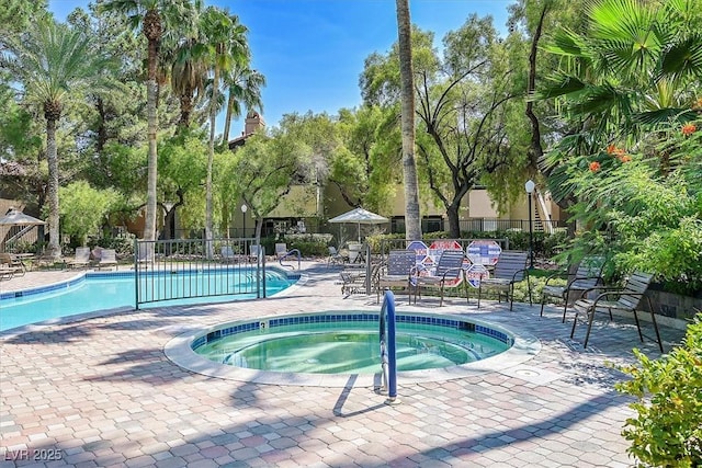 pool featuring fence, a hot tub, and a patio area
