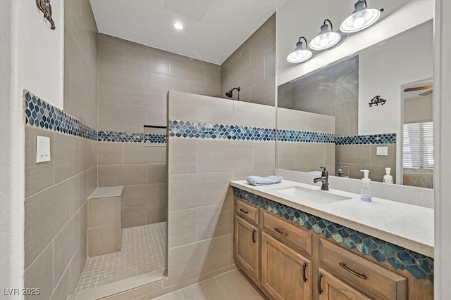 bathroom with tile walls, a walk in shower, vanity, tile patterned floors, and recessed lighting