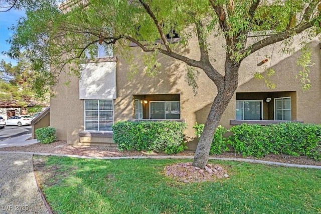 view of front of property featuring a front lawn and stucco siding