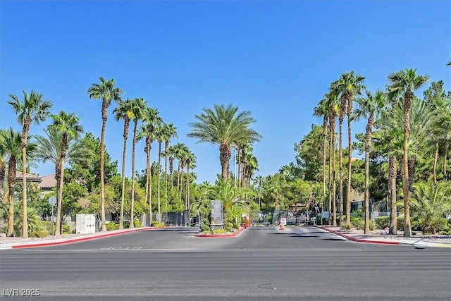 view of road with curbs, a gated entry, and sidewalks