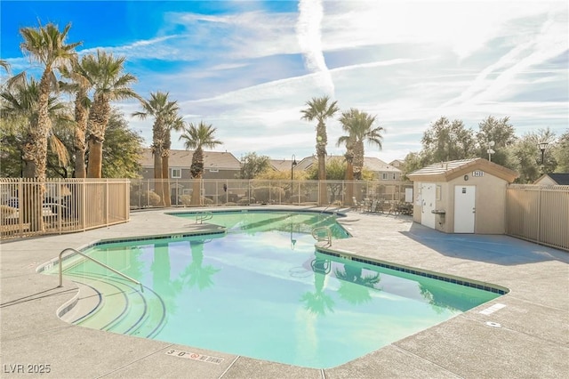 pool featuring fence, a patio, and a residential view