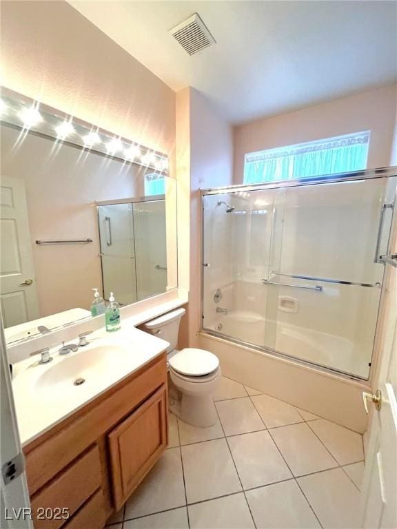 2925 Big Green Ln, Las Vegas, NV 89134 - full bathroom with toilet, vanity, tile patterned floors, and bath / shower combo with glass door