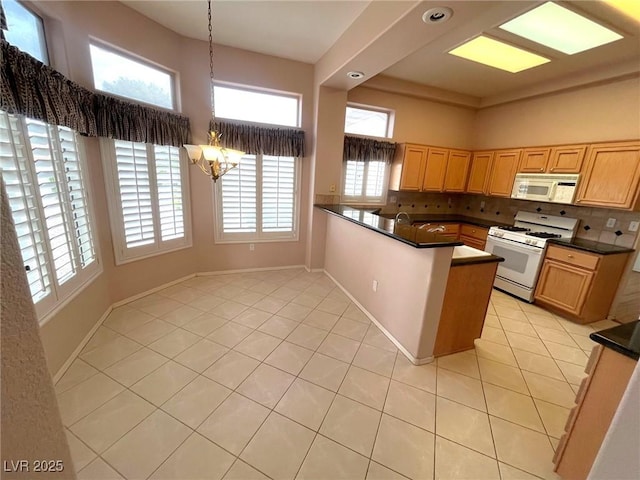 2925 Big Green Ln, Las Vegas, NV 89134 - kitchen with white appliances, light tile patterned floors, a chandelier, dark countertops, and a high ceiling