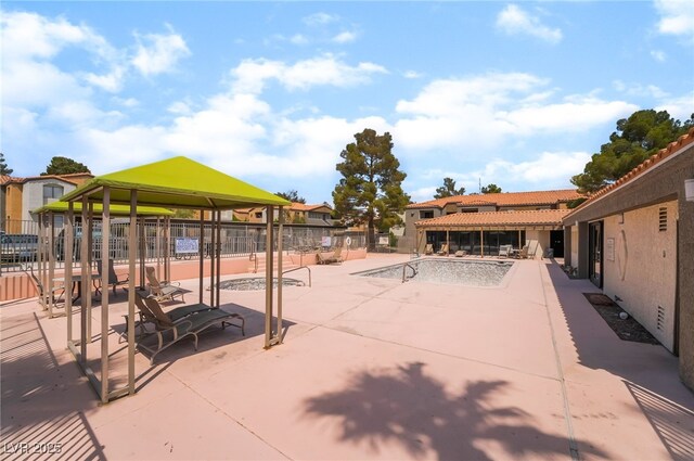 view of patio / terrace with a community pool, a gazebo, and fence