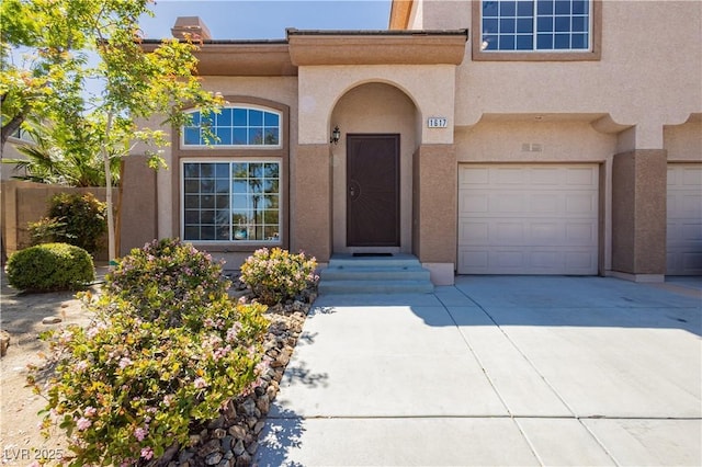 1617 Cave Spring Dr, Henderson, NV 89014 - property entrance featuring a garage, stucco siding, and driveway