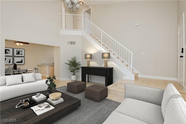 1617 Cave Spring Dr, Henderson, NV 89014 - living area with visible vents, a towering ceiling, a notable chandelier, and stairway
