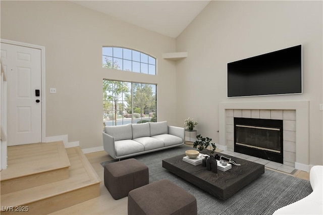 1617 Cave Spring Dr, Henderson, NV 89014 - living area featuring baseboards, high vaulted ceiling, and a tile fireplace