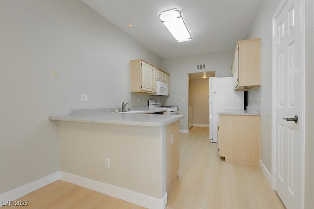 1617 Cave Spring Dr, Henderson, NV 89014 - kitchen featuring a sink, light wood finished floors, white appliances, light countertops, and a peninsula