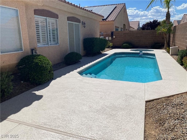 view of swimming pool with a patio, a pool with connected hot tub, and a fenced backyard