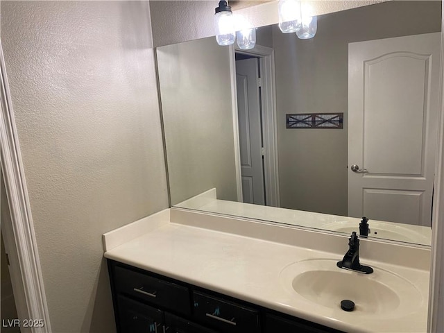 bathroom featuring a textured wall and vanity